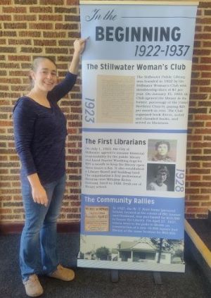 Elizabeth Murray poses with a panel from the library's new history display.
